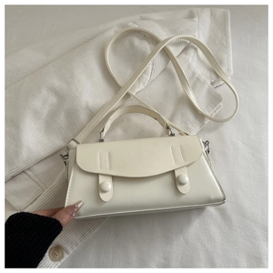 Detail of cream white mini handbag with curved flap, matte leather texture and silver hardware