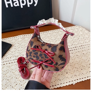 Detail of leopard print crescent bag with red leather trim and delicate lace handle