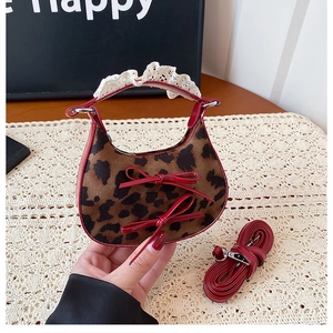 Detail of leopard print handbag with red leather trim and white lace handle decoration