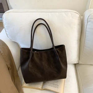Retro minimalist large capacity dark brown tote bag with matte texture on white sofa