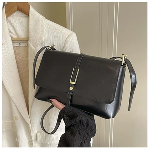 Gros plan détaillé du sac à bandoulière noir brillant avec boucle en métal doré