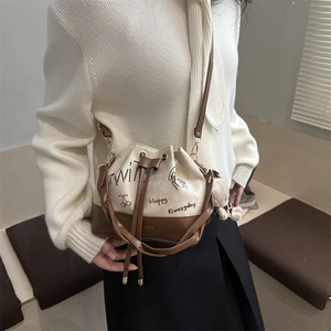 Stylish bucket bag in cream canvas and brown leather with drawstring closure