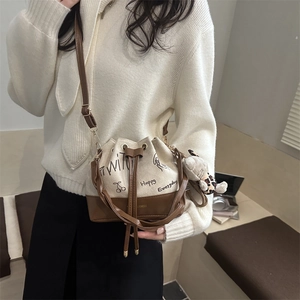 Fashionable color-block bucket bag with graffiti print and a cute bear charm pendant