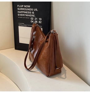 Detail of vintage brown tote bag with wide shoulder strap and silver hardware accents