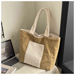 Close-up of large brown suede tote bag with white faux shearling pocket and handle
