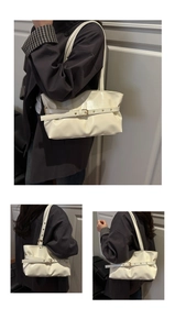 Detail view of cream vintage faux leather shoulder bag with buckle strap and pleated texture