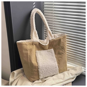 Detail of khaki corduroy tote bag with white faux shearling pocket in a cozy setting