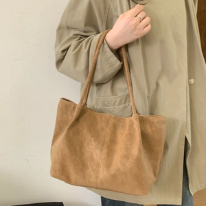 Close-up of brown faux suede tote bag featuring high-quality velvet texture and handle detail