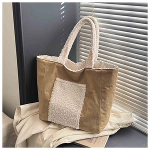 Detail of caramel brown suede tote bag with white sherpa trim and large front pocket