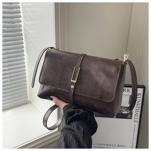 Détail du sac à bandoulière marron vintage avec boucle métallique dorée élégante