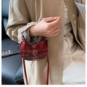 Elegante borsa a quadri rossi con fiocchi, mostrata portata a mano da una modella