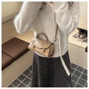 Detail of vintage crossbody square bag in brown PU leather shown with elegant shoulder strap