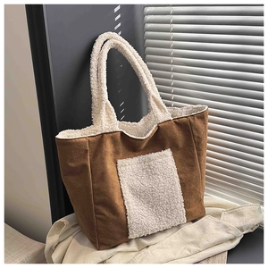 Detailed view of large brown faux suede tote bag with white teddy fleece trim and pocket
