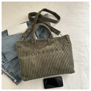 Détail de la texture du velours côtelé vert armée et de la broderie TOTE BAG