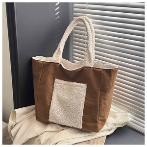 Detail of faux shearling trim on large brown suede tote bag with front pocket