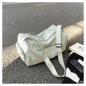 Detail view of mint green waterproof sports bag with adjustable strap on street ground