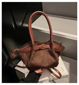 Detail of vintage matte brown suede bucket bag with leather buckle and top handle