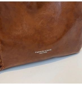 Detail view of brown vintage leather bag with Fashion & Bags printed text