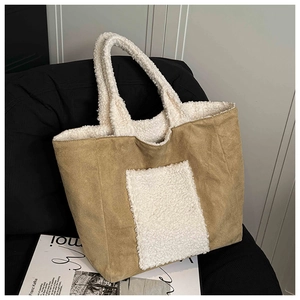 Detail of khaki tote bag with plush white faux shearling trim on a textured black seat