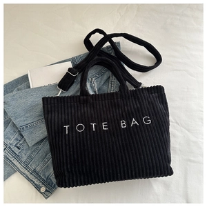 Détail du sac cabas en velours côtelé noir avec broderie TOTE BAG et bandoulière