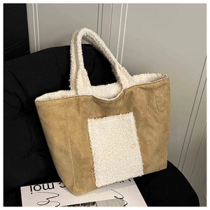 Detailed shot of large brown suede tote bag with white faux shearling trim and pocket