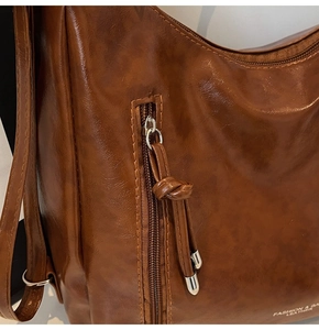 Detail of caramel brown faux leather with lychee texture and vertical zipper pocket