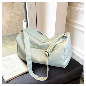 Detail of mint green waterproof yoga bag with adjustable strap and front zipper pocket