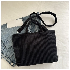 Détail du sac cabas en velours côtelé noir avec crochets en métal et bandoulière