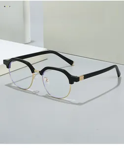 Detail of black and gold semi-rimless glasses with decorative gold metal hinge texture