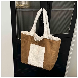 Detail of plush tote bag featuring brown suede and white faux shearling trim accents