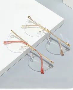 Detail of 2024 rimless cat eye glasses with pink gold and gold temples on white props