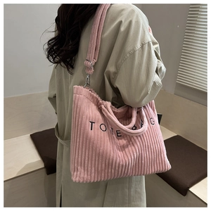 Détail du cabas en velours côtelé rose avec broderie et crochets métalliques argentés