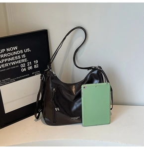 Brown semi-circle hobo bag shown with a tablet computer to demonstrate large capacity
