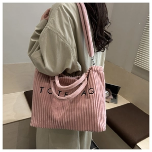 Détail du sac cabas en velours côtelé rose avec broderie et bandoulière ajustable