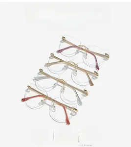 Close-up of four rimless cat-eye glasses frames in pink, gold, silver, and dark red colors