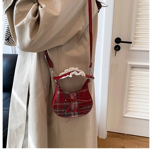 Mini borsa a tracolla a quadretti rossi con fiocco e pizzo indossata da una modella