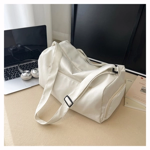 Detail view of large white waterproof gym bag with smooth leather finish and sturdy zippers