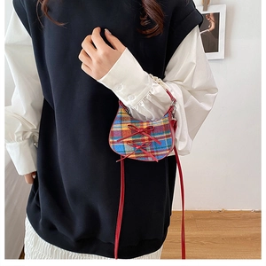 Mini plaid crossbody bag featuring decorative red bows and a leather shoulder strap