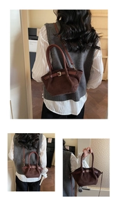 Detail view of dark brown suede handbag with leather handles and gold buckle strap