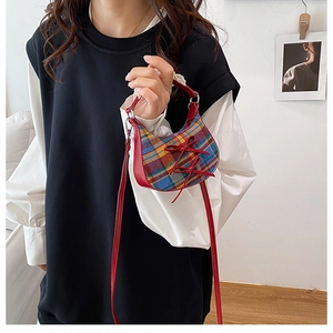 Dettaglio della mini borsa vintage a quadri con finiture in pelle rossa e fiocchi