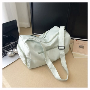 Close-up of a mint green gym bag with side zipper pockets and adjustable straps in a modern scene