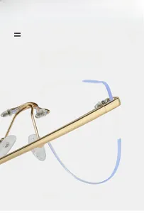Detail of rimless cat-eye glasses frame with gold metal hinges and flexible temples