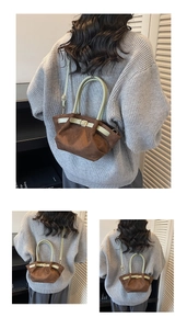 Detail of a brown suede bucket bag with green leather handles and adjustable shoulder strap