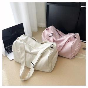 Detailed view of large capacity fitness bags in cream and pink with durable straps