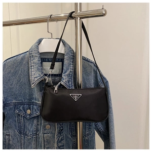 Close-up of black nylon underarm bag with silver triangular logo and smooth finish