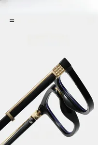 Detail of square glasses hinge showing golden textured metal decoration and lightweight frame