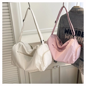 Detail view of white and pink nylon travel bags with multiple zippered pockets