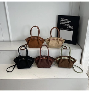 Collection of suede Boston handbags in black brown and olive green on display