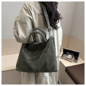 Détail du cabas en velours côtelé vert foncé avec lettrage TOTE BAG brodé en noir