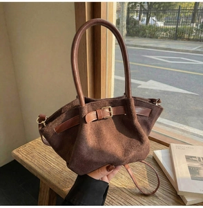 Detail of coffee suede tote bag showing texture, metal buckle and leather handle